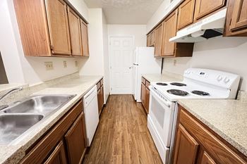 an empty kitchen with wood flooring and white appliances at Deercross Apartments, Cincinnati, OH